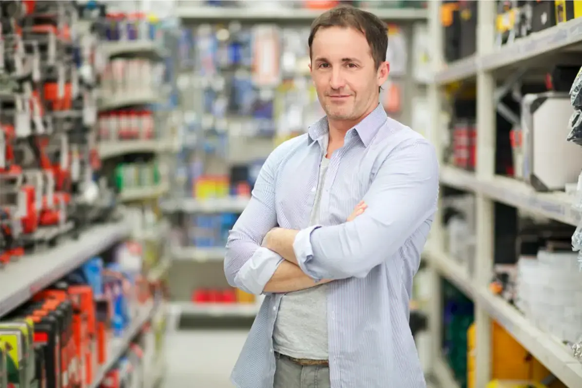 Hardware store owner standing confidently in the middle of an aisle