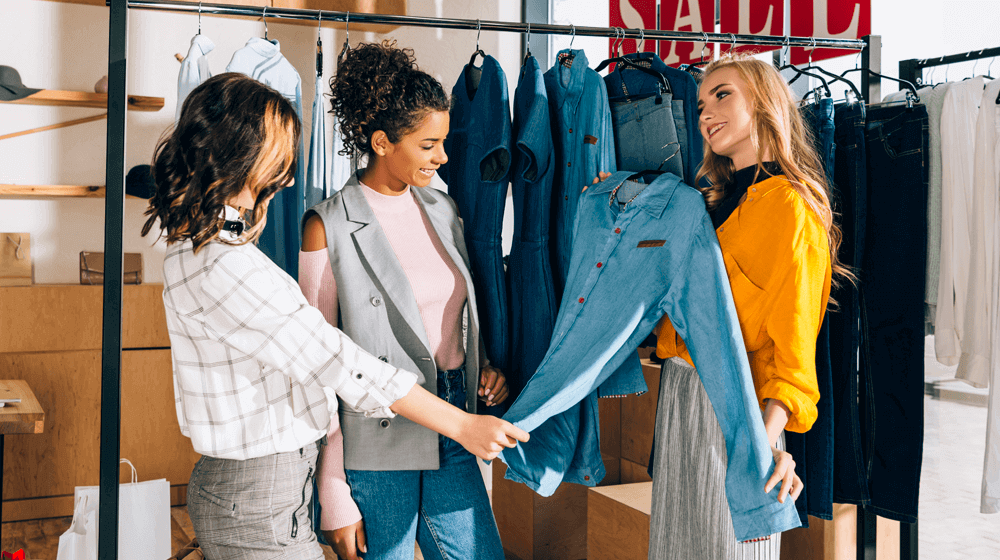 Customers in a clothing store looking at a jean shirt